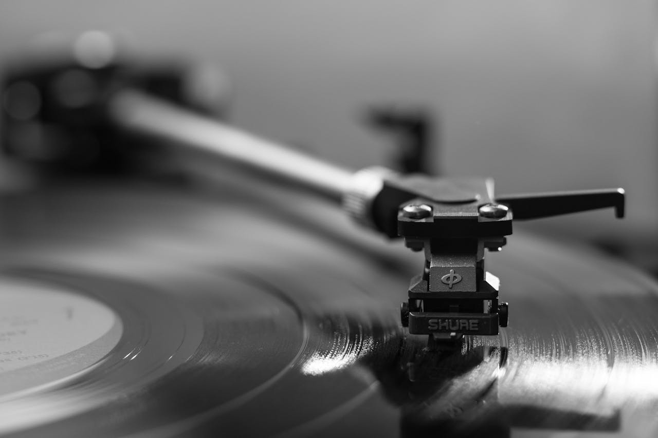 services-07 Black and white close-up of a turntable playing a vinyl record, emphasizing vintage aesthetics.