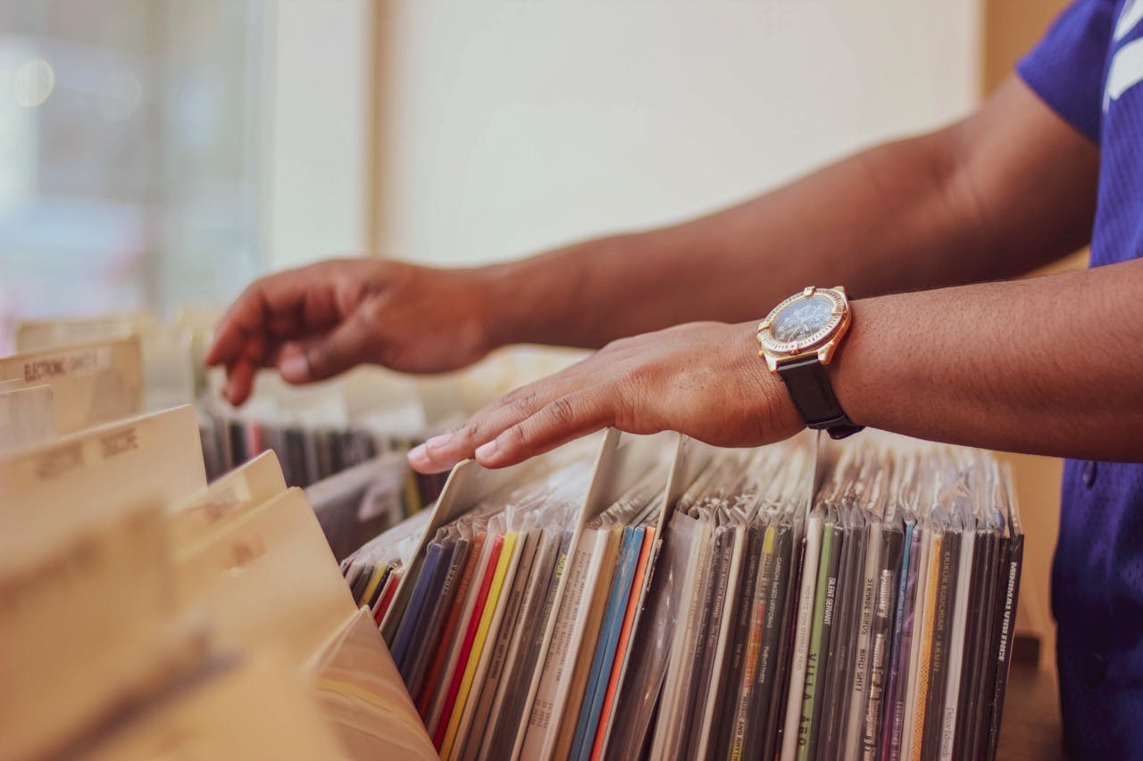 services-08 Close-up of hands browsing vinyl records in a store, showcasing a classic vintage collection.