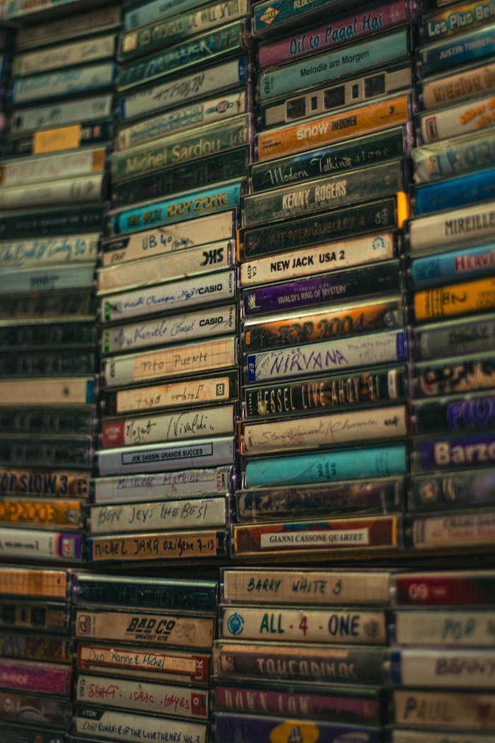 services-01 A nostalgic collection of various music cassette tapes stacked vertically.