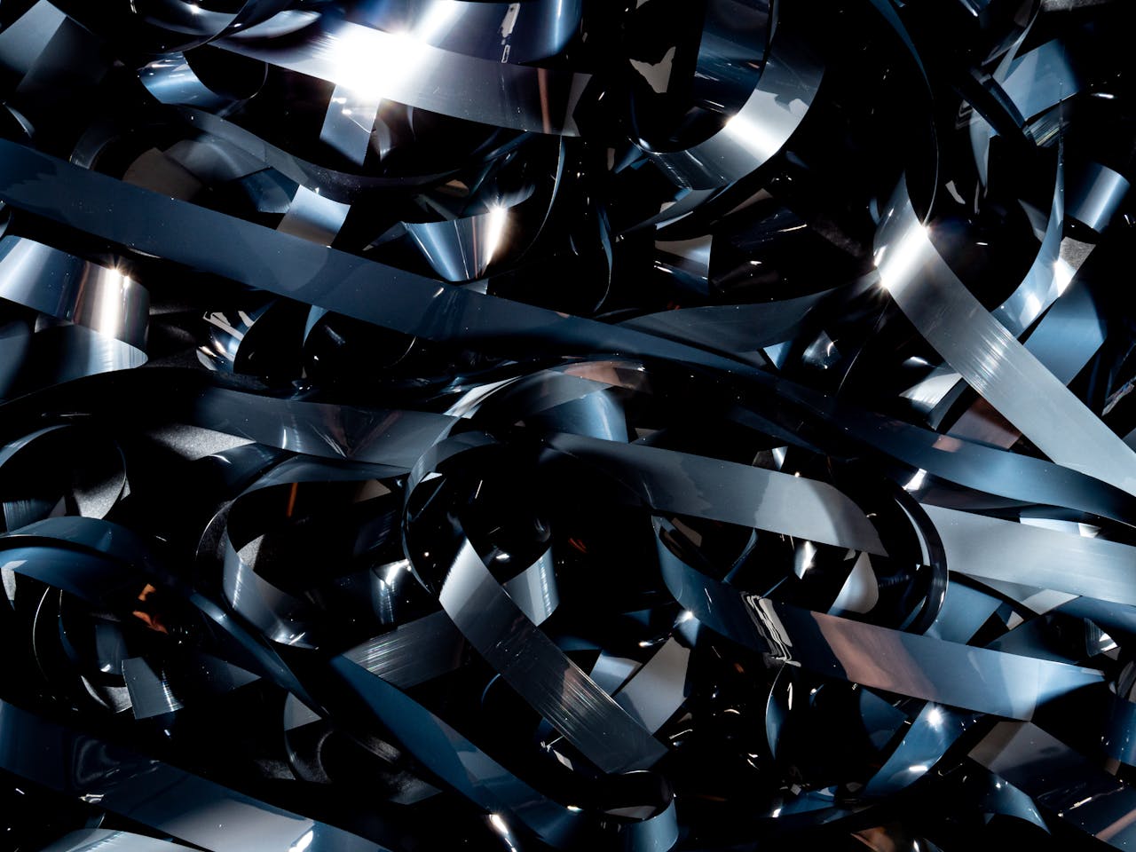 services-03 Close-up view of tangled audio cassette tapes with a reflective surface.